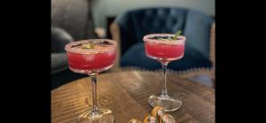 two wine glasses sitting on top of a wooden table at Stylish Scottish House with garden and parking in Perth