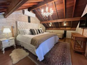 a bedroom with a large bed and a chandelier at Pousada Dona Bendita in Monte Verde
