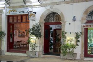 a white building with an entrance to a restaurant at Kiniras Traditional Hotel & Restaurant in Paphos