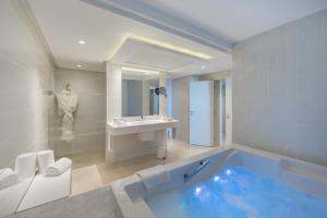 a bathroom with a large tub and a sink at Royal Azur Thalassa in Hammamet