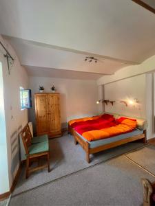 1 dormitorio con 1 cama grande y 1 silla en Agro - Dom Wsrod Lasow, en Trzcianka