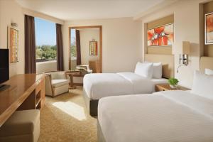 a hotel room with two beds and a television at InterContinental Al Jubail Resort in Al Jubail