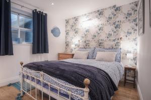 um quarto com uma cama azul e branca e uma janela em Goscar Court - 1 Bedroom Apartment - Tenby em Tenby