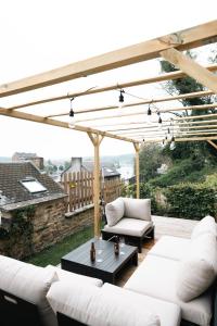 a patio with white couches and a table at La petite Citadelle - l'appartement in Namur