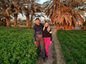 Ein Mann und eine Frau, die auf einer unbefestigten Straße spazieren in der Unterkunft Village Room in the Countryside in al-Minya