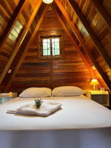 ein Schlafzimmer mit einem großen Bett im Dachgeschoss in der Unterkunft Chalé do Portal in Monte Verde