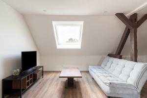 a living room with a couch and a tv at Gemütlich 5 in Wissembourg