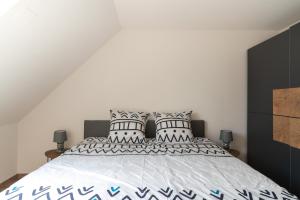 a bedroom with a bed with black and white pillows at Gemütlich 5 in Wissembourg