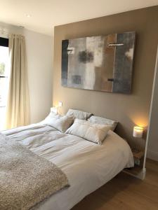 Una cama con sábanas blancas y almohadas en un dormitorio en Chambre d'Hôte Touquet's Garden, en Cucq
