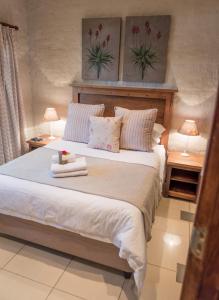 a bedroom with a large bed with two lamps at Chateau B&B in Piet Retief