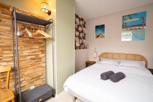 sypialnia z łóżkiem i drewnianą ścianą w obiekcie Cabana & La Parmelante - Proche Lac w Annecy