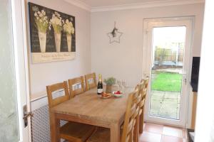 a dining room with a wooden table and chairs at Bluebell Place in Chelmsford