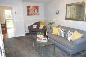uma sala de estar com dois sofás e uma mesa em Bluebell Place em Chelmsford