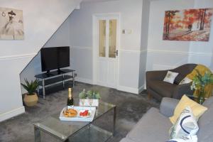 a living room with a couch and a tv at Bluebell Place in Chelmsford