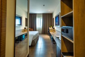 a hotel room with a bed and a bathroom at Amika Hotel,Madurai - Near Airport in Madurai