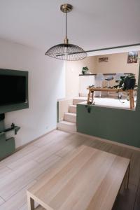 a living room with a tv and a table at La petite Citadelle - l'appartement in Namur