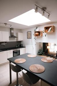 a kitchen with a black table with four chairs at La petite Citadelle - l'appartement in Namur