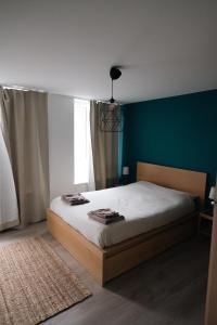a bedroom with a bed and a blue wall at La petite Citadelle - l'appartement in Namur