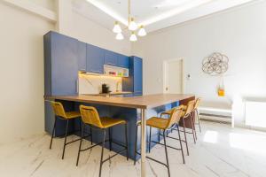 a kitchen with blue cabinets and yellow stools at Bengt Apartment Kiraly str. in Budapest