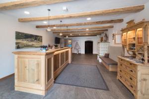 a large room with wooden beams and a kitchen with a counter at Hotel Gasthof Unterwöger in Obertilliach