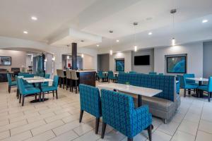 a dining room with blue chairs and tables at Best Western Plus Pauls Valley in Pauls Valley