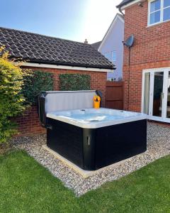a large hot tub in the backyard of a house at Cherry Blossom Place in Tiptree