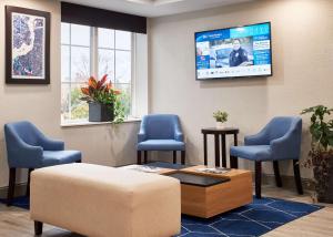 una sala de espera con sillas y TV en la pared en Best Western Plus Executive Residency Pottstown, en Pottstown