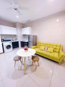 Una sala de estar con un sofá amarillo y una mesa. en Connected train 1 Bedroom ABOVE MALL-16, en Kuala Lumpur 15 fotos más
