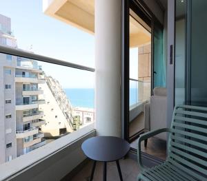 a balcony with a chair and a view of the ocean at West Tel Aviv- All Suites Hotel By The Sea in Tel Aviv