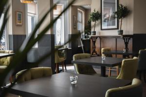 un restaurante con mesas, sillas y ventanas en Bude Hotel - An Mor, en Bude