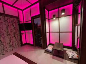 Habitación con luces rosas en las paredes y ventanas en MagicSuite Guest House Roma Vaticano, en Roma