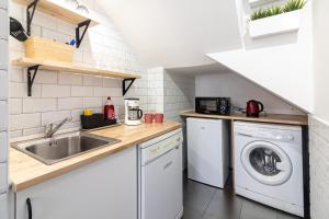 een kleine keuken met een wastafel en een wasmachine bij Precioso estudio en centro historico de Malaga in Málaga