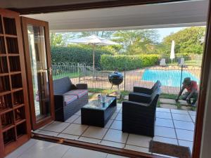 een afgeschermde veranda met uitzicht op een zwembad bij Pearl Cottage in Durban