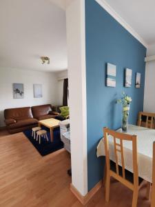 een woonkamer met blauwe muren en een tafel en een bank bij 2 Bedroom Apartment in De Haan in De Haan