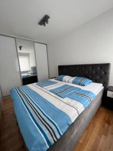 een bed met een blauw en wit dekbed in een slaapkamer bij 3RooM Deluxe Sarajevo in Sarajevo