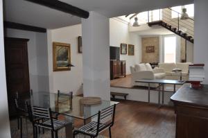 een woonkamer met een glazen tafel en stoelen bij Casa di Mario appartamento in centro storico con due camere da letto e terrazze in Cagliari