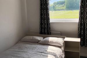 1 cama en un dormitorio con ventana en Modern two bedroom house near beach/ Durham City en Hawthorn