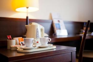 a coffee maker and two cups on a table at Hotel Felix in Warsaw