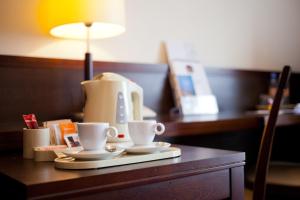 una cafetera y dos tazas en una mesa en Hotel Felix, en Varsovia