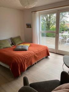 a bedroom with a bed and a sliding glass door at Brøndums Bed & Breakfast in Hjørring