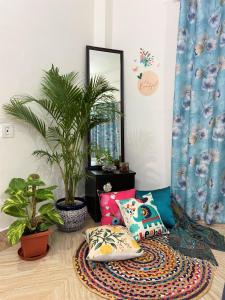 um quarto com plantas e um espelho e almofadas em Bhuman Homestay em Siliguri