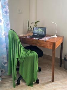 einen Holzschreibtisch mit einem Laptop auf einem Stuhl in der Unterkunft Bhuman Homestay in Shiliguri