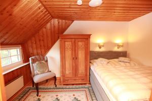 1 dormitorio con 1 cama y 1 silla en una habitación en Alte Scheune en Ahrenshoop