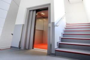 un couloir avec des escaliers dans un bâtiment avec une porte dans l'établissement Apartment London, à Mühlhausen