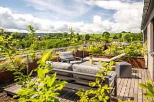 a patio with a couch and chairs on a balcony at Boutiquehotel Genusswerk Eifel in Körperich