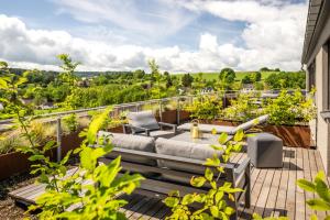 patio con sofá y sillas en el balcón en Boutiquehotel Genusswerk Eifel en Körperich