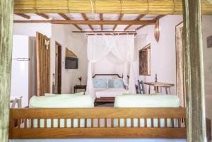 a bedroom with two beds and a table at ViverTrancoso in Trancoso