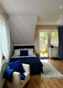 a bedroom with a bed and a couch with blue pillows at Apartament Katarina 2 in Ustrzyki Dolne