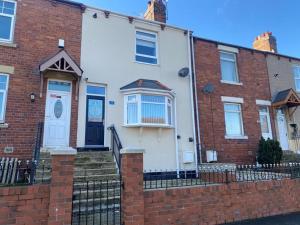 una casa in mattoni rossi con una porta blu di Modern two bedroom house near beach/ Durham City a Hawthorn