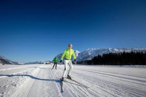 dos personas en esquís en la nieve en Haus Sonja en Grundlsee